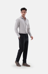 Helles graues Langarmshirt, dunkle Slim-Fit-Hose und graue Knöchelstiefel. Das Shirt hat einen Kragen und Knöpfe; der Stoff wirkt glatt.