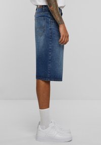Denim hame vaale keskipitkä, polven pituinen, suora leikkaus. Sisältää klassisen viisi-tasku-designin ja keskikokoisen tekstuurin.