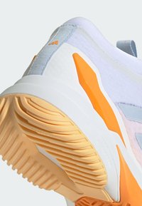 Scarpa da ginnastica bianca con suola testurizzata. Presenta accenti azzurri e arancioni, un colletto imbottito e un design rinforzato sulla punta.