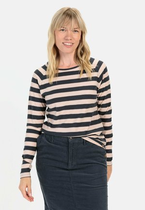 Haut à manches longues rayé en beige et marine, avec un col rond et une coupe décontractée, associé à une jupe en denim foncé.