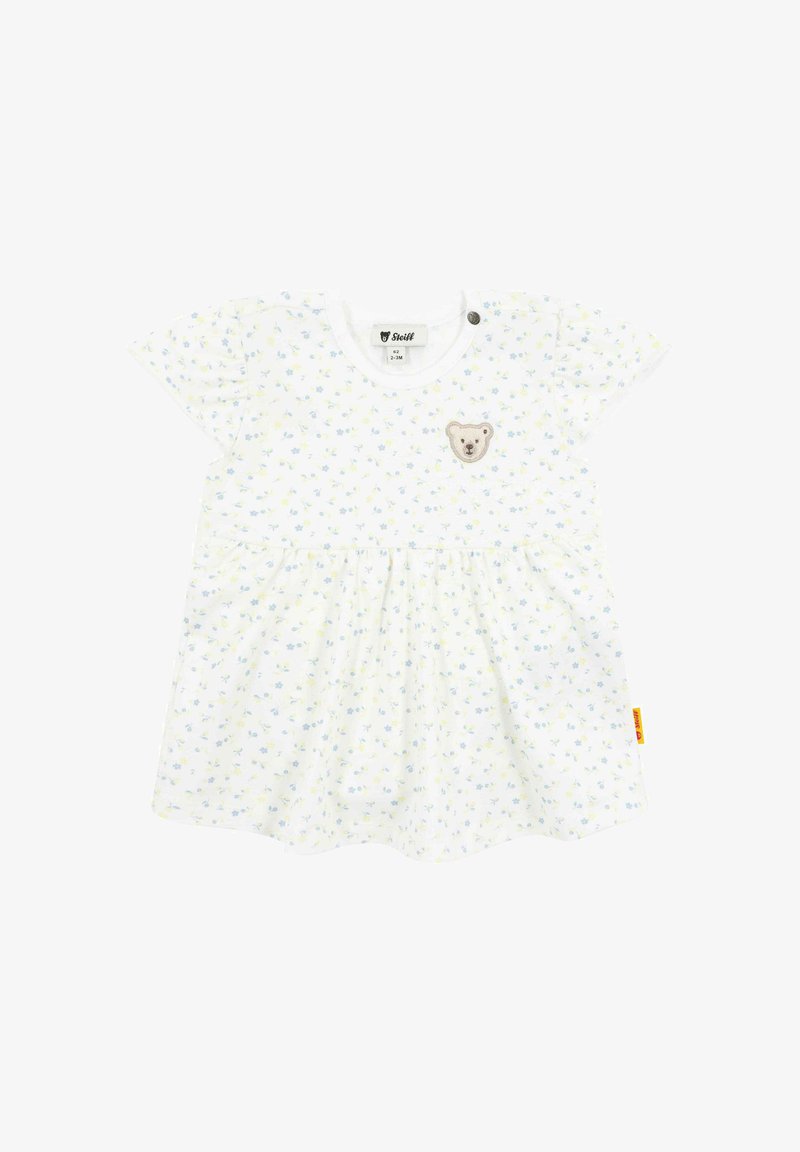 Bílé šaty s malým modrým a žlutým květinovým vzorem, kulatým výstřihem, krátkými rukávy a aplikací medvídka na hrudi. Sukně je rozšířená.