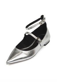 Zapato plano metálico plateado con puntera afilada y doble correa en el tobillo, forro interior negro y un pequeño tacón. Textura suave con mínimas decoraciones.