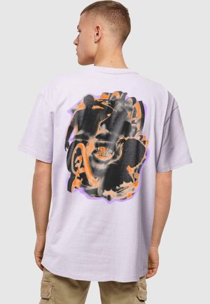Lilla grafisk t-skjorte med en svart og oransje abstrakt design på ryggen, laget av myk bomullsstoff med en avslappet passform.