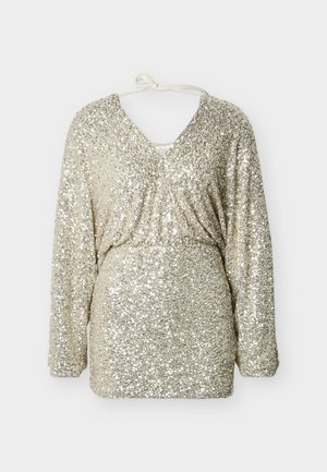 Haut à manches longues en or scintillant avec un col en V, doté d'une taille froncée et d'un détail noué à l'arrière, recouvert de paillettes réfléchissantes.