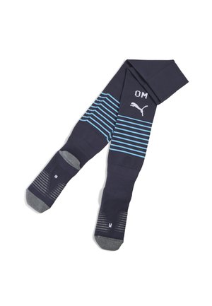 Chaussettes de sport bleu marine avec des rayures horizontales bleu clair, portant un logo Puma et le texte "OM". Comprend des sections rembourrées au talon et aux orteils en gris.