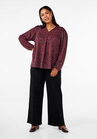 Camicia a maniche lunghe bordeaux con motivo, scollo a V, abbinata a pantaloni neri a palazzo. Tessuto morbido, vestibilità comoda, design geometrico sottile.