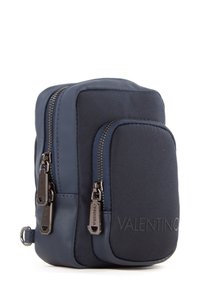 Geantă compactă de culoare albastru marin, cu două compartimente cu fermoar, realizată din piele netedă și material texturat, având logo-ul „Valentino” embosat.