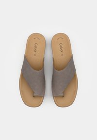 Sandali a scivolo in suede grigio con design a fascia incrociata e una soletta sagomata color tan, con cuciture sottili lungo i bordi.