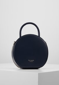 Borsa rotonda blu navy realizzata in pelle liscia, con mano superiore e hardware dorato, con il nome del brand impresso sul davanti.