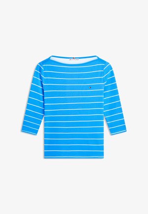 Gaiši zils krekls ar garām piedurknēm, ar plānām horizontālām baltām svītrām un nelielu taisnstūrveida logo kreisā krūtīs.