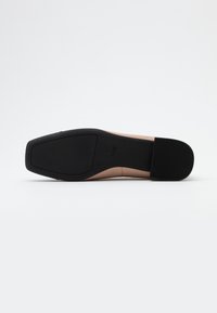 Nude skórzany but na wysokim obcasie z prostokątnym noskiem i teksturowaną czarną podeszwą; prosty i elegancki design.