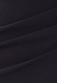 Black textured fabric with a slight sheen, featuring subtle wave patterns and draped folds, conveying a soft and smooth appearance.