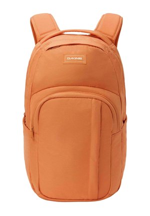 Zaino Dakine arancione con spallacci imbottiti, maniglia superiore, tasca frontale con zip e tasche laterali su sfondo bianco.