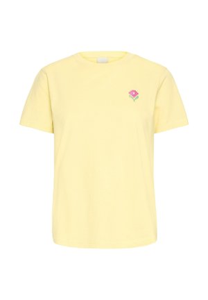 T-shirt gialla a maniche corte con un piccolo fiore rosa e gambo verde sulla parte sinistra del petto.