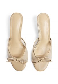 Beige nät- och läderöppna sandaler med platt klack, prydda med en slinga framtill och en slät, texturerad yta.