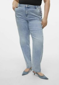 Ljusblå denimjeans med rak passform, fem fickor och midjehögt midjeband, ihop med spetsiga blå klackar.