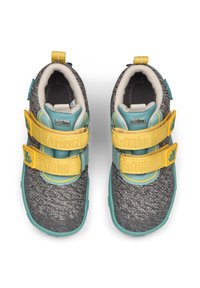 Scarpe grigie lavorate a maglia con accenti gialli e turchesi. Presentano due cinturini in Velcro gialli e una parte superiore in tessuto testurizzato. Interno morbido e imbottito.