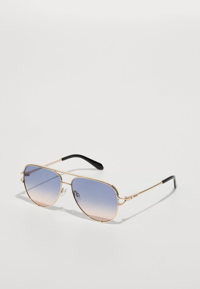 Gold-framed aviator sunglasses with gradient blue-to-pink lenses and black temple tips on a plain white background.
