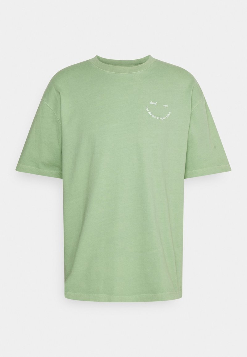 T-shirt en coton vert clair avec un col rond, des manches courtes et un graphique texte blanc : "les yeux fermés mais toujours l'esprit ouvert."