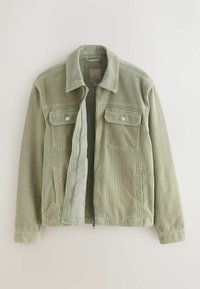 Veste en velours côtelé vert clair avec col, deux poches à rabat sur la poitrine avec boutons, poches latérales, et une fermeture éclair avant partiellement ouverte.
