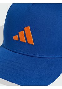 Blue baseball cap made of textured fabric, featuring an orange embroidered three-stripe logo on the front and a flexible curved brim.