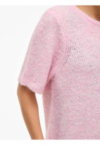 Roosa kootud kampsun, mis on lõdva lõikega, lühikeste varrukatega ning pehme ja karvane tekstuuriga. Omab kergelt avatud mustrit, et võimaldada õhku läbi tulla.