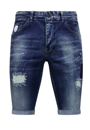 Donkerblauwe denim shorts met versleten patches, opgerolde zomen en verfspatten. Heeft vijf zakken en een doodskopontwerp op de voorkant.