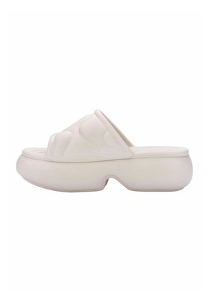 Sandalo bianco texturizzato con design ondulato, con punta aperta e suola piatta spessa, realizzato in materiale flessibile.