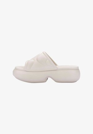 Biały teksturowany klapek na platformie z falistym wzorem, z odkrytymi palcami i grubą podeszwą, wykonany z elastycznego materiału.