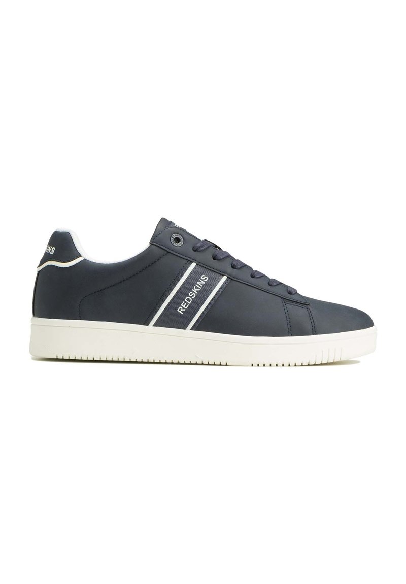 Zapatillas sintéticas azules con suela y cordones blancos. Presentan franjas blancas con el texto "REDSKINS". Punta redondeada y suela exterior de goma texturizada.