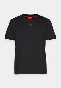 T-shirt nero a maniche corte con collo a girocollo, dotato di una piccola patch con il logo Hugo centrata sul petto e un'etichetta del colletto interno di colore rosso.