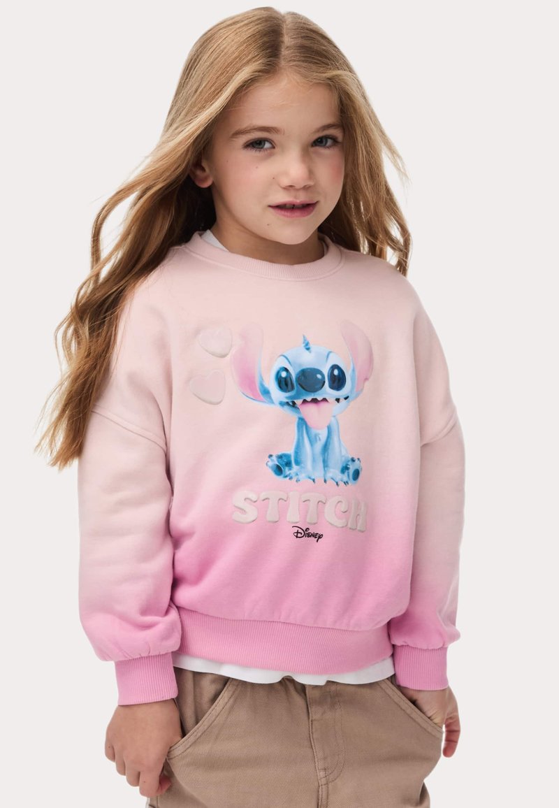 Sweatshirt rose avec un design dégradé mettant en avant Stitch de Disney. Comprend des accents en relief et des poignets côtelés, fabriqué en tissu doux.