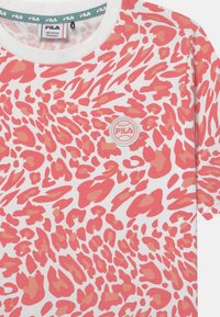 Koszulka z krótkim rękawem z miękkiej bawełny, z różowo-koralowym nadrukiem w gepardy na białym tle. Zawiera okrągłe logo FILA.