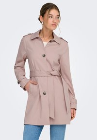 Trench-coat rose clair en tissu lisse, doté d'une ceinture à la taille, de grands boutons et de poches latérales, avec un col classique et des épaulettes.
