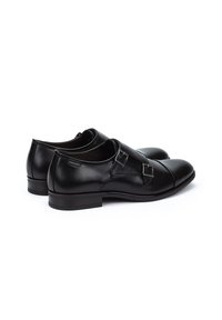 Zwarte leren schoenen met dubbele gespdetails, rond te ontwerpen, lage hak, gladde textuur en minimale stiksel. 