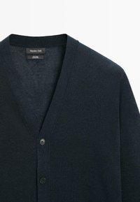 Mørk marineblå hørcardigan med V-hals, to sorte knapper og Massimo Dutti-mærke inde i kraven.