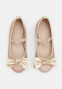 Ballerine rosa glitterate con un fiocco in satin dorato sulla punta. Presentano una soletta imbottita e una fascia elastica, design con punta arrotondata.