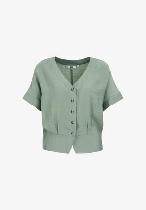 Világoszöld, rövid ujjú blúz V-kivágással, elöl hét gombbal és enyhe ráncolással a deréknál. Simább textúrájú.