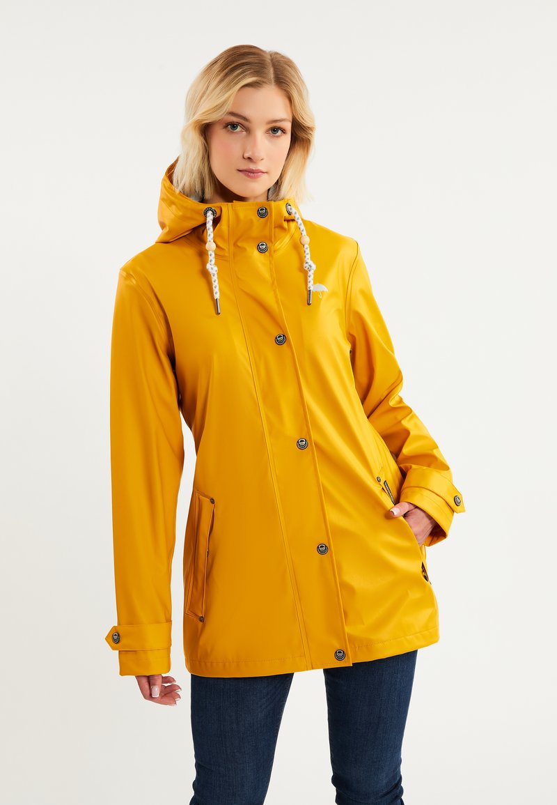 Chaqueta de lluvia amarilla impermeable con capucha, botones a presión, detalles con cordón y bolsillos laterales. Textura suave y brillante.