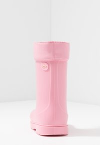Botas de lluvia de goma rosa con una forma redondeada, un puño suave y una suela texturizada. Presentan un pequeño logo de la marca en el costado.