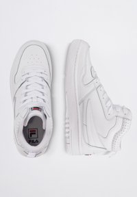 Zapatillas altas blancas de cuero suave, con perforaciones, cordones planos y suela de goma texturizada. Logo de Fila en la lengüeta.
