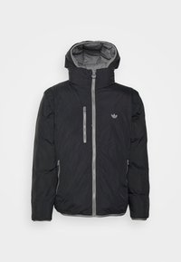 Svart vadderad jacka med huva och grå dragkedja. Har en bröstficka och logotypprydnad. Slät textur och något glansig finish.