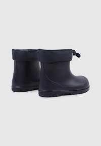 Paire de bottes en caoutchouc imperméables bleu marine avec poignets rembourrés rabattables et fermetures à cordon, conçue pour une utilisation en extérieur.