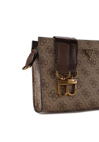 Bruine schoudertas met patroon en leren accenten, goudkleurige hardware, dubbele klikhaken en een verstelbare riem. Voorzien van logodetails.