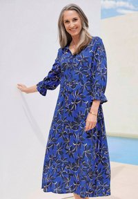 Blaues Blumenkleid mit langen, gepufften Ärmeln und einer durchgehenden Knopfleiste. Es hat einen lockeren Schnitt und eine geraffte Taille. Blumendruck in Schwarz und Beige.