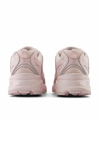 Light pink athletic shoes feature a mesh upper, padded collar, and textured sole with traction patterns. Designed for comfort and stability.