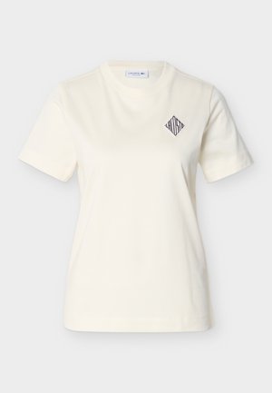 Kremfarvet bomulds-t-shirt med rund halsudskæring, korte ærmer og en diamantformet broderet logo på venstre bryst. Glat tekstur.