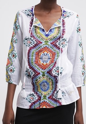 Witte blouse met kleurrijke tie-dye geometrische patronen, driekwartmouwen, V-hals met kwastjes en een geplooide taille.