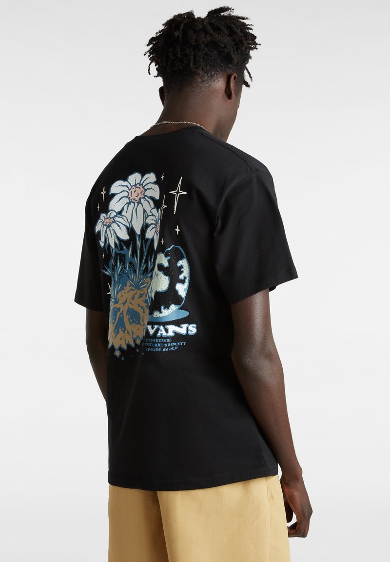 Camiseta de algodón negra con un diseño gráfico que presenta flores blancas y acentos azules en la parte posterior. Manga corta y cuello redondo.