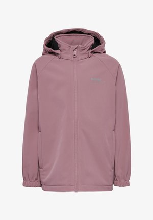 Barn med rødt hår iført en lavendel hættetrøje, grå skjorte, mørke jeans og blå sneakers, som står på en hvid baggrund.